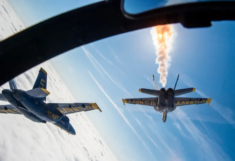 Photograph from a pilots perspective as Blue Angels race through the clouds.