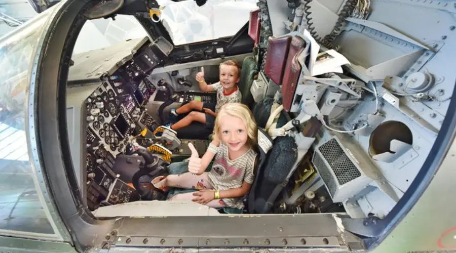 Kids in the cockpit of a retired aircraft from WWII.