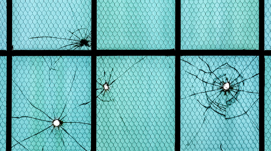 Photograph of bullet holes in the window of hangers.