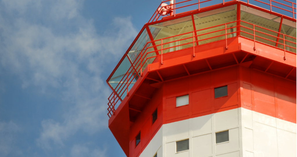 Photo of Ford Island Control tower with blue sky behind it.