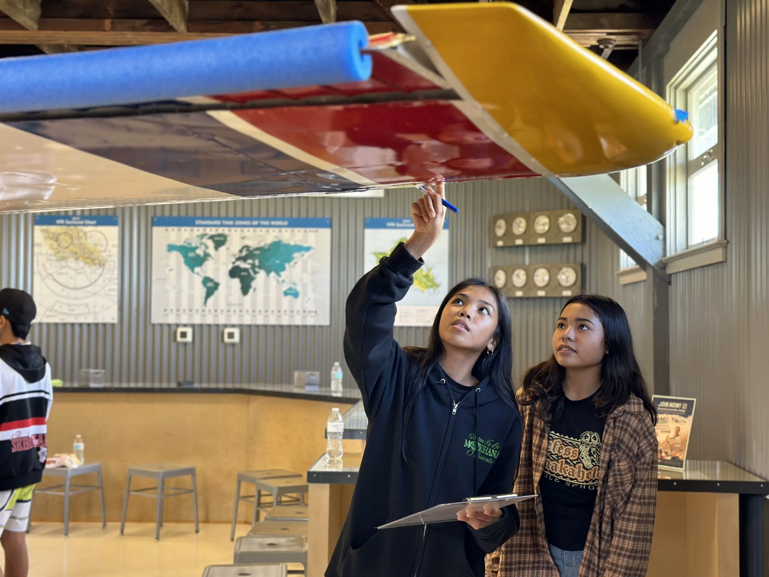 Photo of student looks at the wing of an airplane