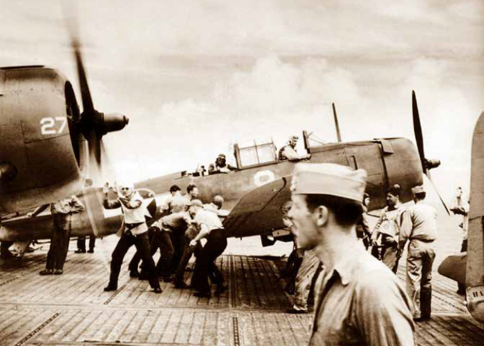 Flight deck crew of USS Yorktown secure SBD Dauntlesses that have just struck Japanese-held islands in 1943.