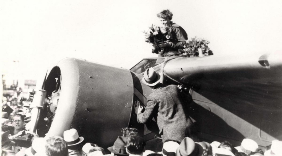 Earhart receiving bouquet after landing at Oakland Field after her flight from Hawaii