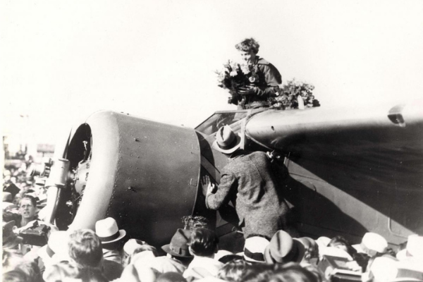 Earhart receiving bouquet after landing at Oakland Field after her flight from Hawaii